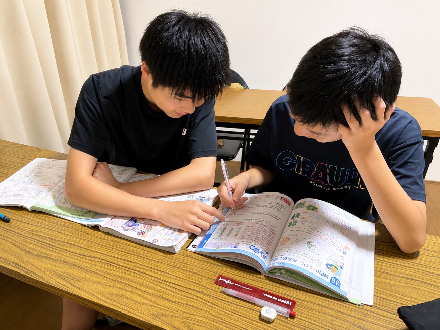 教科書を見ながら一緒に学習する中学生